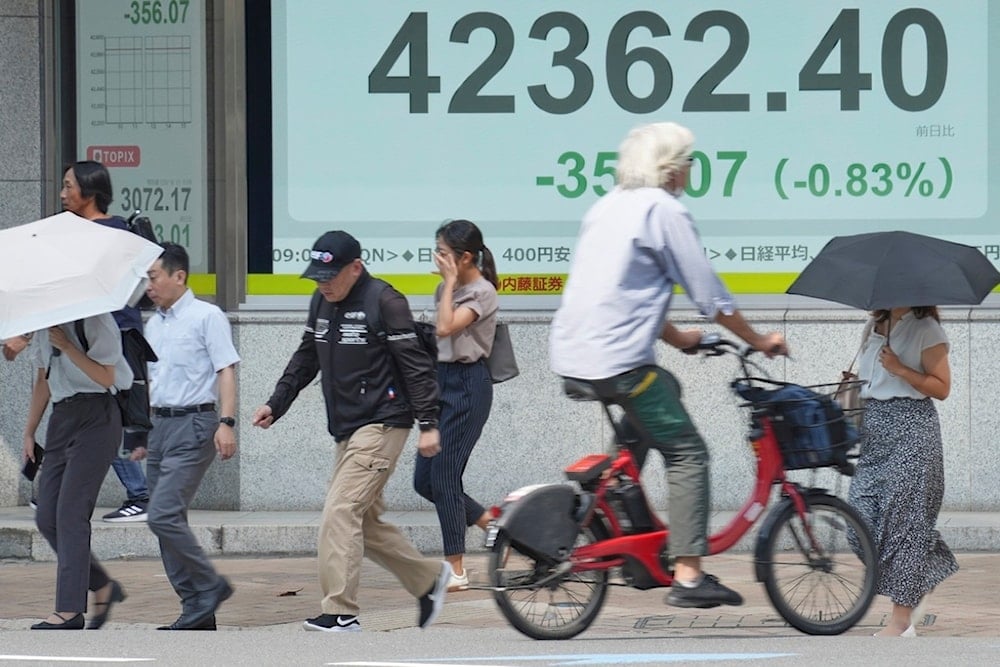 People walk in front of an electronic stock board showing Japan's Nikkei index at a securities firm Monday, September 1, 2025, in Tokyo. (AP)  