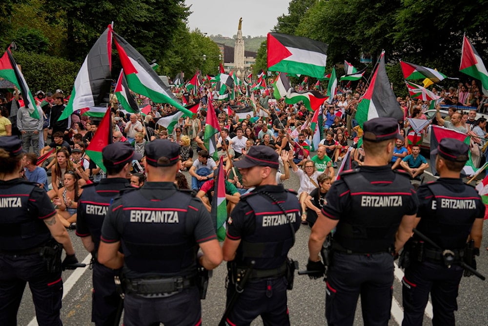 People holding Palestinian flags sit on the street after disrupting the eleventh stage of the Spanish Vuelta cycling race, from Bilbao to Bilbao, Spain, Wednesday, September 3, 2025. (AP Photo/Miguel Oses)