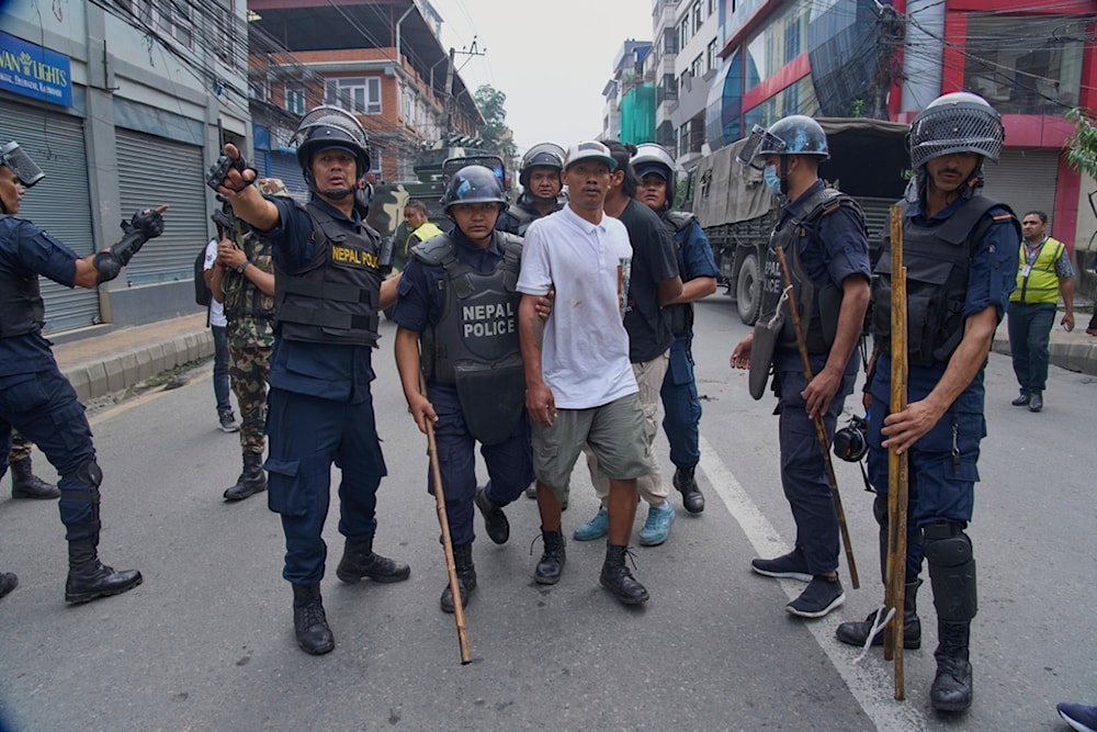 Policemen arrest a prisoner who escaped from Dilli Bazaar jail in Kathmandu, Nepal, Wednesday, September 10, 2025. (AP Photo/Niranjan Shrestha)
