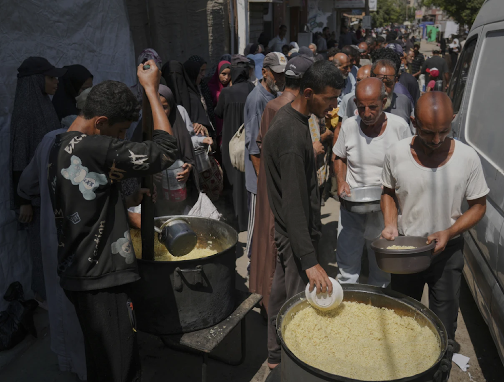 Palestinians line up to receive donated food at a community kitchen in Deir al-Balah in southern Gaza on September 6, 2025. (AP)