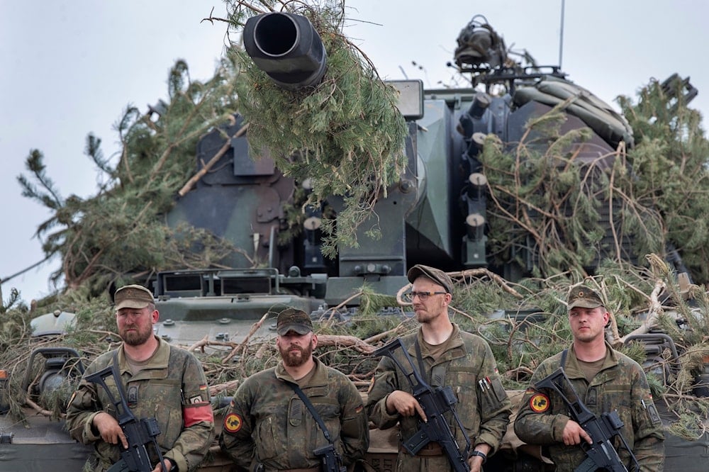 German Bundeswehr soldiers stand next to a self-propelled howitzer PzH 2000 of German Army during the Lithuanian-German division-level international military exercise 'Grand Quadriga 2024', May 29, 2024 (AP)