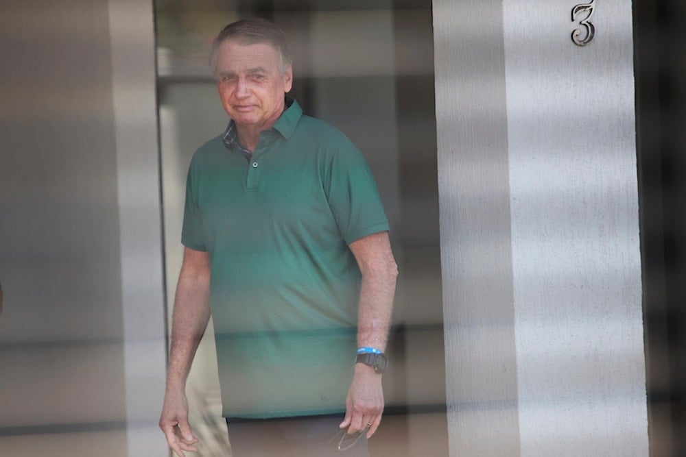 Brazil's former President Jair Bolsonaro stands at the entrance of his home where he is under house arrest in Brasilia, Brazil, Thursday, September 11, 2025 (AP)