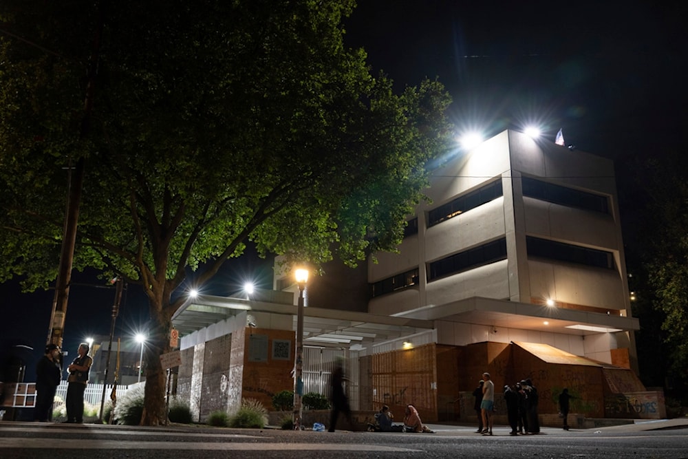 Protesters gather outside the U.S. Immigration and Customs Enforcement building on Wednesday, Sept. 10, 2025, in Portland, Ore. (AP Photo/Jenny Kane)