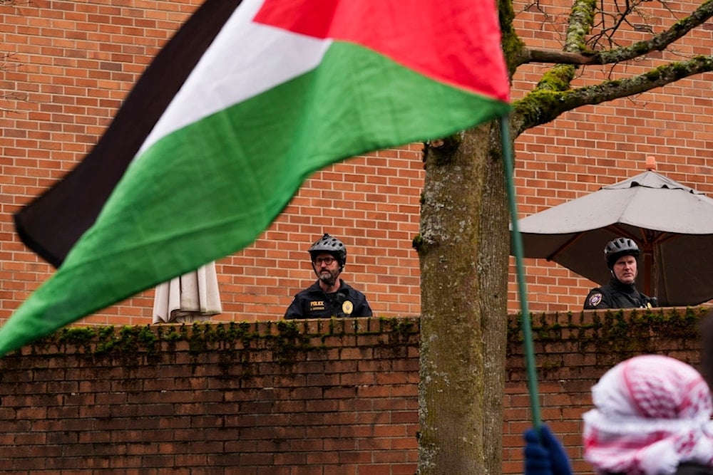 Campus police officers watch as a student-led pro-Palestinian protest marches through the University of Washington campus on Wednesday, February 5, 2025, in Seattle (AP)