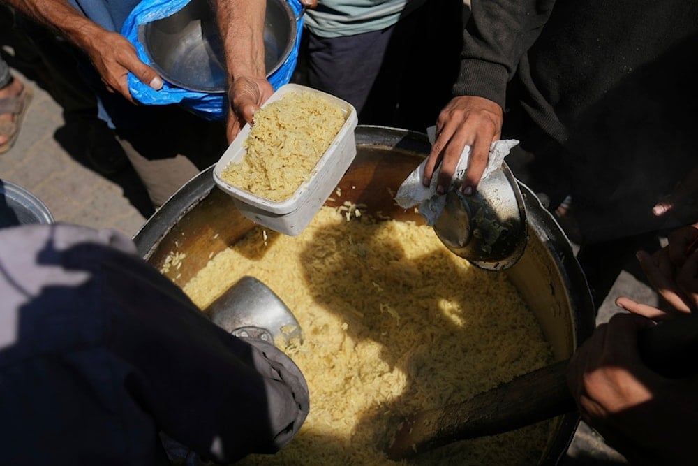 Palestinians receive donated food at a community kitchen in Deir al-Balah, in the central Gaza Strip, Friday, September 12, 2025 (AP)