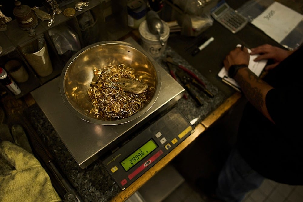 A bowl filled with gold jewelry and a gold bar is weighed at A&M Precious Metals in the St. Vincent Jewelry Center in the Jewelry District of Los Angeles, Friday, May 2, 2025 (AP)