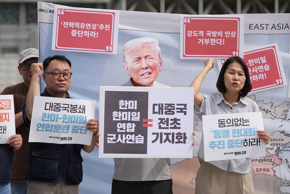 A protester wearing a mask of US President Donald Trump and others shout slogans during a press conference to oppose the military exercise called Freedom Edge near the US Embassy in Seoul, South Korea, Monday, Sept. 15, 2025 (AP)