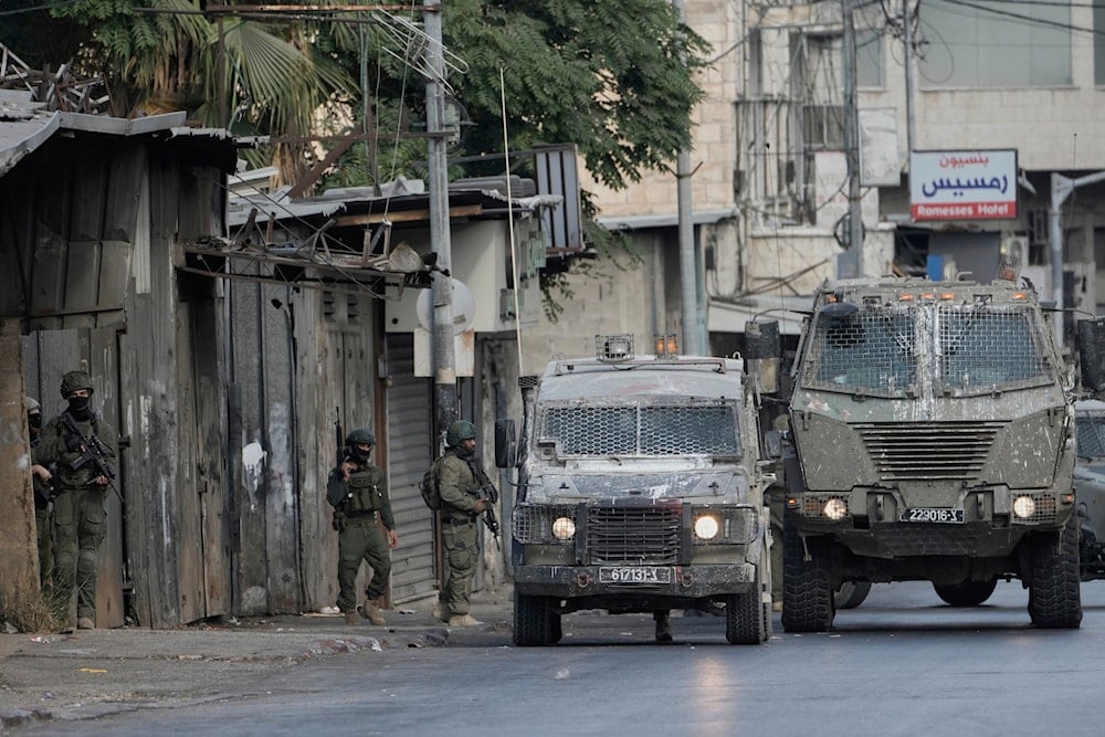 Members of Israeli security forces stand next to armored vehicles during a military raid in the West Bank city of Nablus, Wednesday, Aug. 27, 2025 (AP)