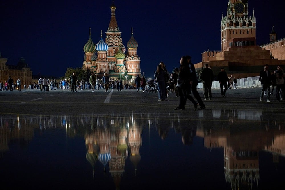 People enjoy a warm evening walking on Red Square in Moscow, Russia, Wednesday, September 10, 2025, with the St. Basil's Cathedral and the Spasskaya Tower in the background. (AP Photo/Alexander Zemlianichenko)