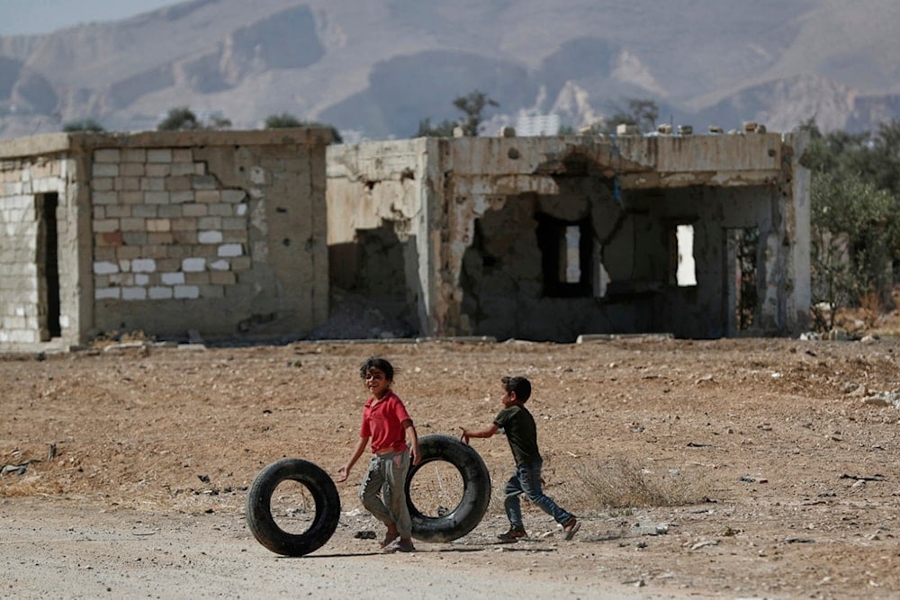 Syrian children play with old tires in the war-damaged town of Douma, Syria, Tuesday, September 16, 2025. (AP Photo/Omar Sanadiki)