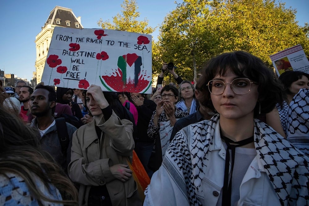 A woman holds a banner reading 'From the river to the sea, Palestine will be free' during a pro-Palestinian gathering at Republic Square, in Paris, Wednesday, September 17, 2025 (AP)
