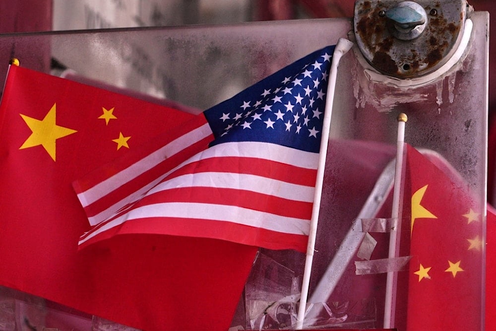 China and US national flags are seen on display on an entrance door of a souvenir shop in Beijing on April 3, 2025. (AP Photo/Andy Wong)