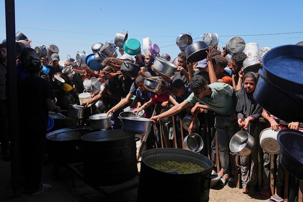 Palestinians struggle to get donated food at a community kitchen in Khan Younis, southern Gaza Strip, Monday, Sept. 1, 2025. (AP Photo/Abdel Kareem Hana)