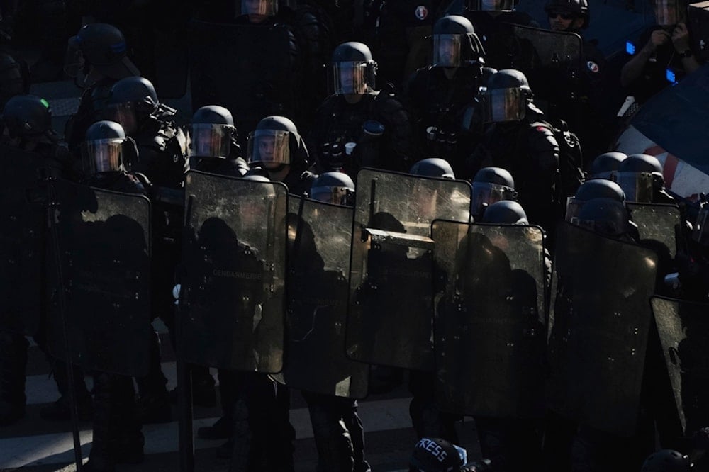 Police officers stand guard during a demonstration called by major trade unions to oppose budget cuts, in Paris, France, Thursday, September 18, 2025 (AP)