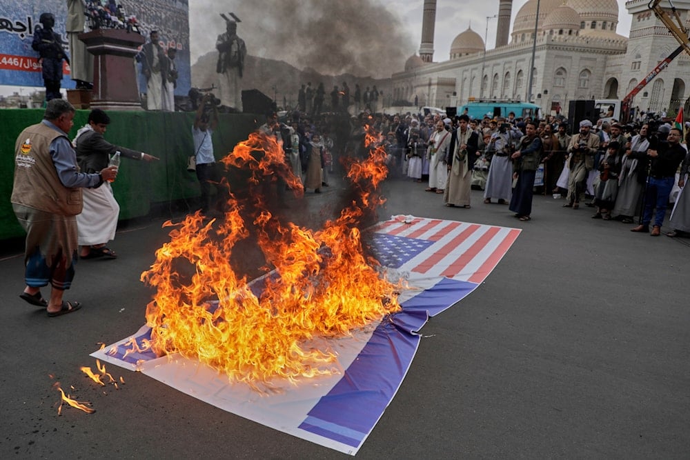 Ansar Allah supporters burn an American and and an Israeli flags during a rally, in Sanaa, Yemen, Friday, April 18, 2025 (AP)