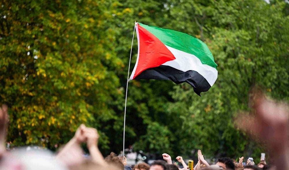 The flag of Palestine is waved in a crowd as the hip hop trio Kneecap perform in Finsbury Park on Saturday, July 5, 2025, in London. (AP)