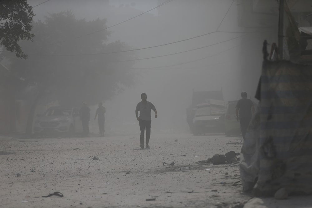 Palestinians walk through dust moments after an Israeli strike that destroyed a residential building in Gaza City, Monday, Sept. 15, 2025. (AP)