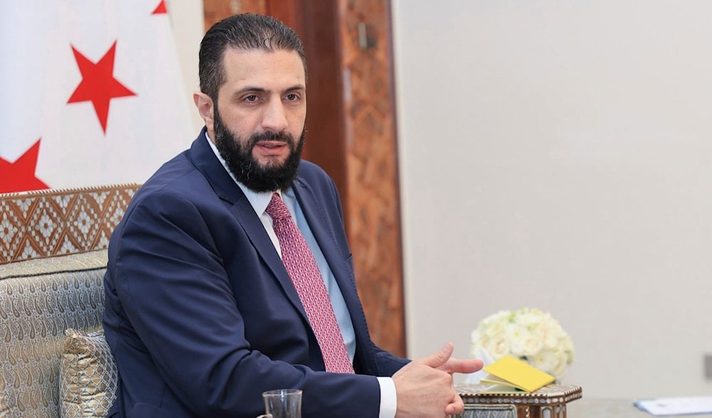 Syria's interim President Ahmad al-Sharaa receives the final version of the provisional electoral system for the People's Assembly, in Damascus, Syria, Sunday, July 27, 2025. (SANA via AP)