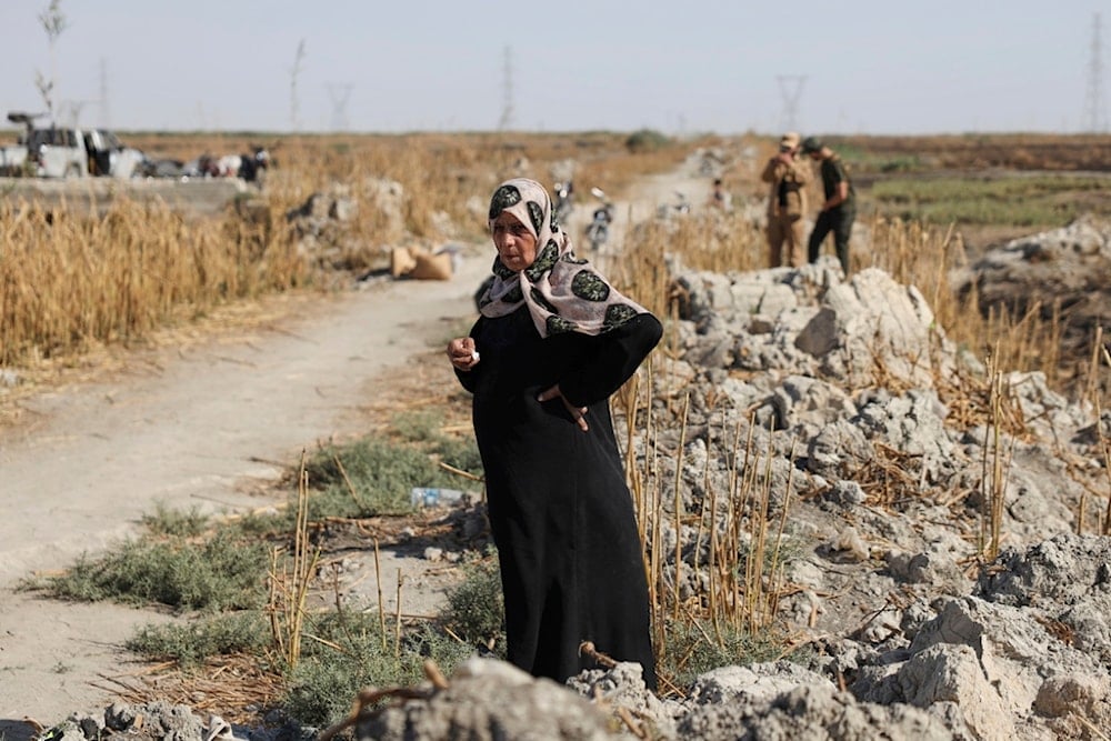 Samira Alloush, searching for her missing son, cries as she watches the Syrian Civil Defense workers inspect clothes found alongside human remains in Otaiba, on the outskirts of Damascus, Syria, Friday, September 19, 2025. (AP Photo/Omar Albam)