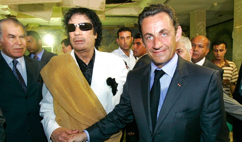Late Libyan leader Moammar Gaddafi shakes hands with former French President Nicolas Sarkozy as they visit a house bombed by American airplanes in 1986 at the Bab Azizia Palace in Tripoli, July 25, 2007. (AP)