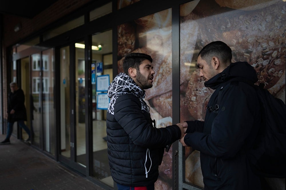 Two immigrants talk outside a shopping mall in Ter Apel, north eastern Netherlands, Thursday, Nov. 9, 2023 (AP)