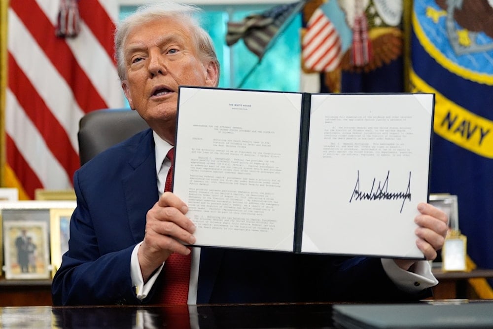 President Donald Trump holds a signed presidential memorandum on the death penalty in the District of Columbia in the Oval Office at the White House, Thursday, September 25, 2025, in Washington (AP)