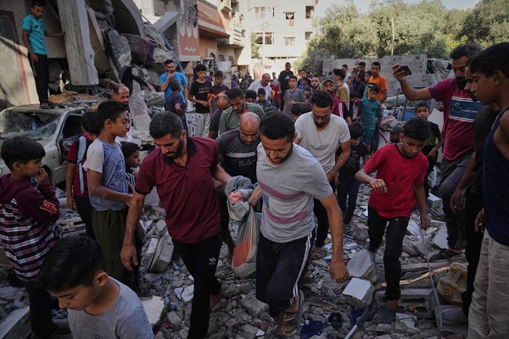 Palestinians carry the body of Hassan Nasr, 12, from the rubble of his relatives home, which was hit by an Israeli military strike in Zawaida, central Gaza Strip, Thursday, September 25, 2025 (AP)