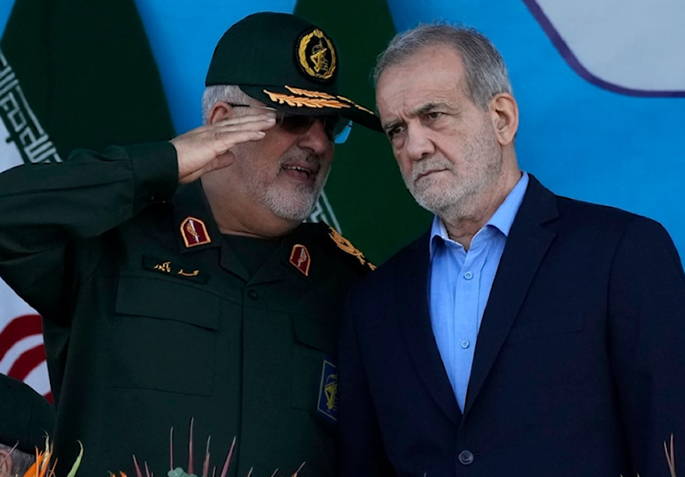 Iranian President Masoud Pezeshkian listens to then-commander of the IRGC's Ground Force, General Mohammad Pakpour as he reviews an annual armed forces parade on September 21, 2024. (AP)