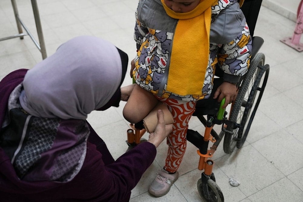 Five-year-old Palestinian Sila Abu Aqlan sits on her wheelchair as a doctor adjusts the cover on her right amputated leg at the Artificial Limbs and Polio Center in Gaza City, Feb. 26, 2025, (AP)