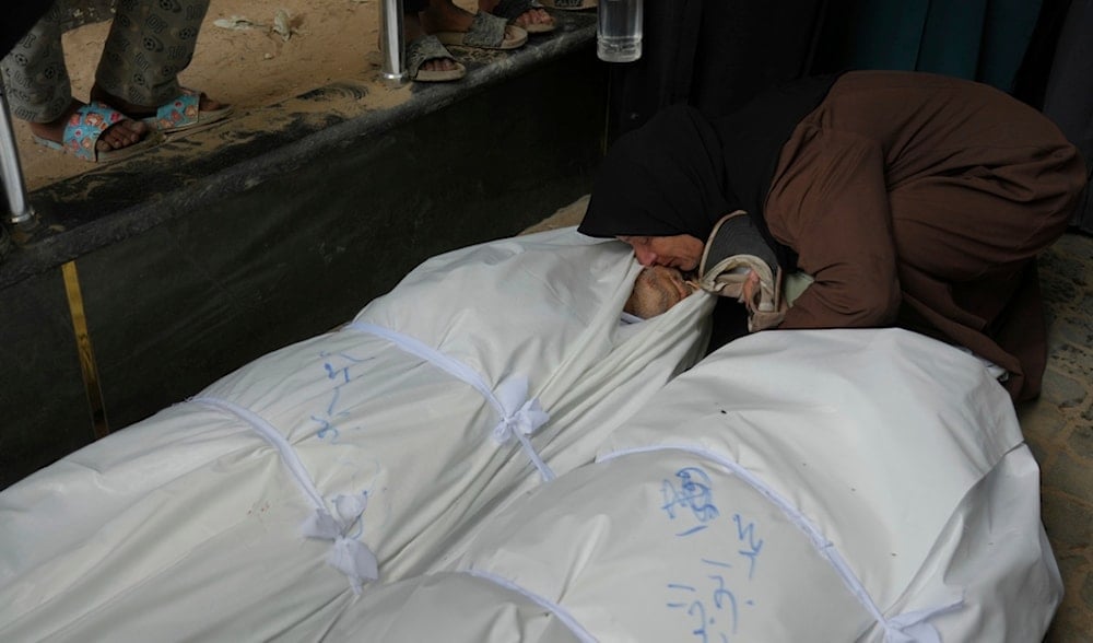 A Palestinian woman mourns over the bodies of people who were killed in an Israeli strike, during their funeral outside Shifa Hospital in Gaza City, Sunday, Aug. 31, 2025. (AP)