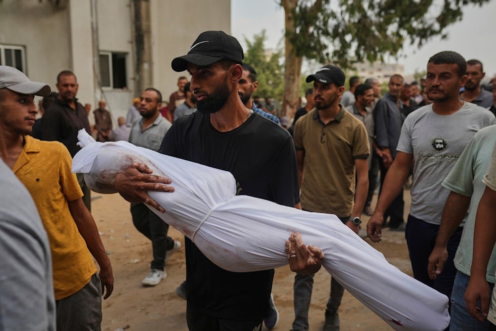 A relative carries the body of Palestinian child Muath Al-Basus, who was killed in an Israeli strike, during his funeral outside Shifa Hospital in Gaza City, Thursday, Sept. 4, 2025 (AP)