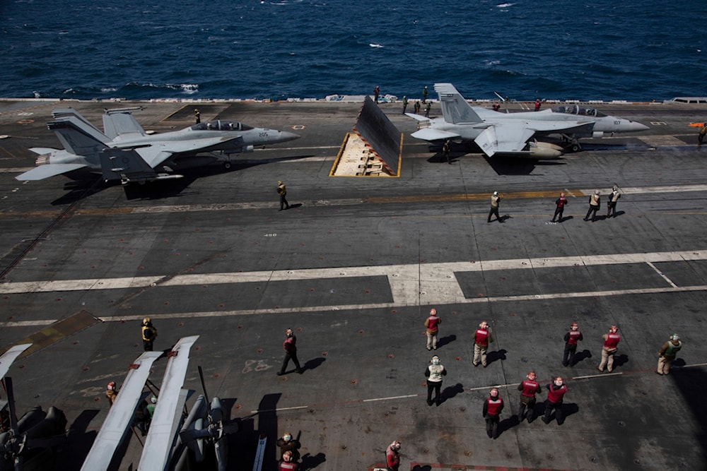 U.S. Navy F-18 Super Hornets and crew members are seen on the flight deck of the USS Nimitz off the coast of Busan, South Korea, Monday, March 27, 2023. (Jeon Heon-kyun/Pool Photo via AP)