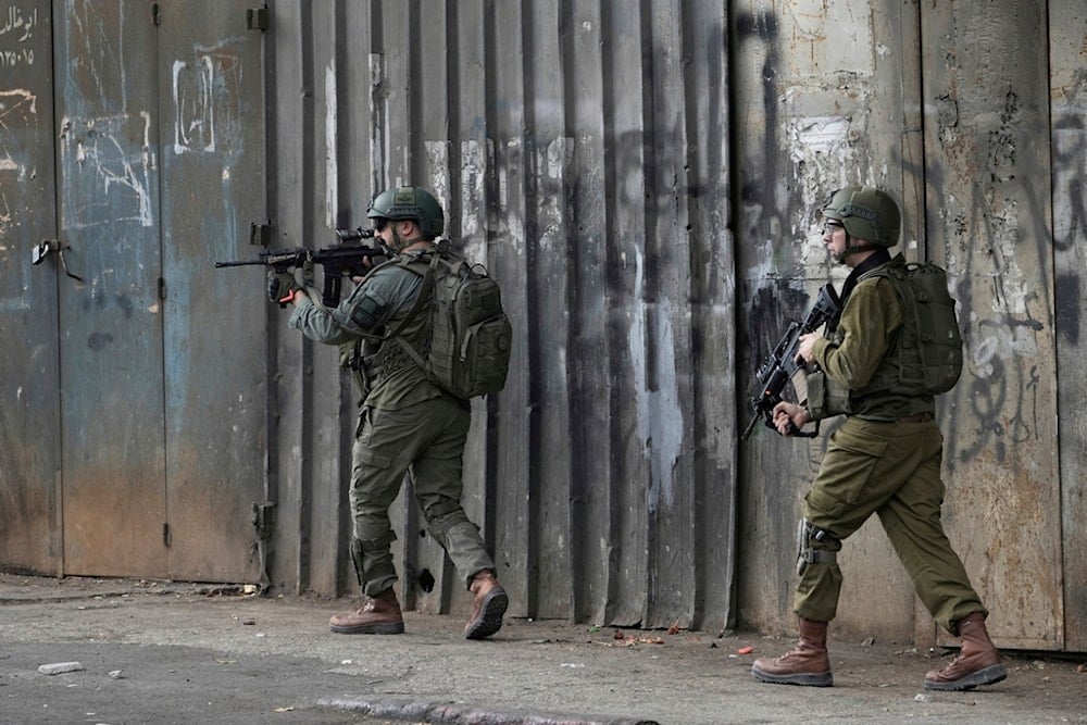 Members of Israeli security forces take position during a military raid in the West Bank city of Nablus, Wednesday, Aug. 27, 2025. (AP Photo/Majdi Mohammed)