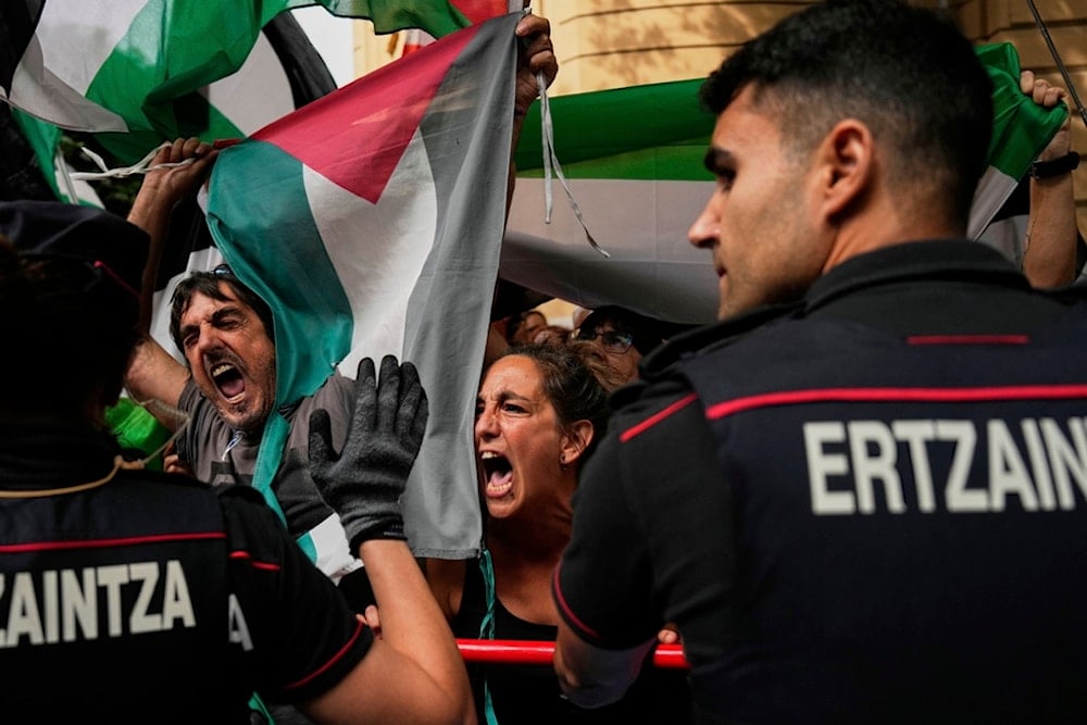 People hold Palestinian flags as they try to disrupt the eleventh stage of the Spanish Vuelta cycling race, from Bilbao to Bilbao, Spain, Wednesday, Sept. 3, 2025. (AP Photo/Miguel Oses)