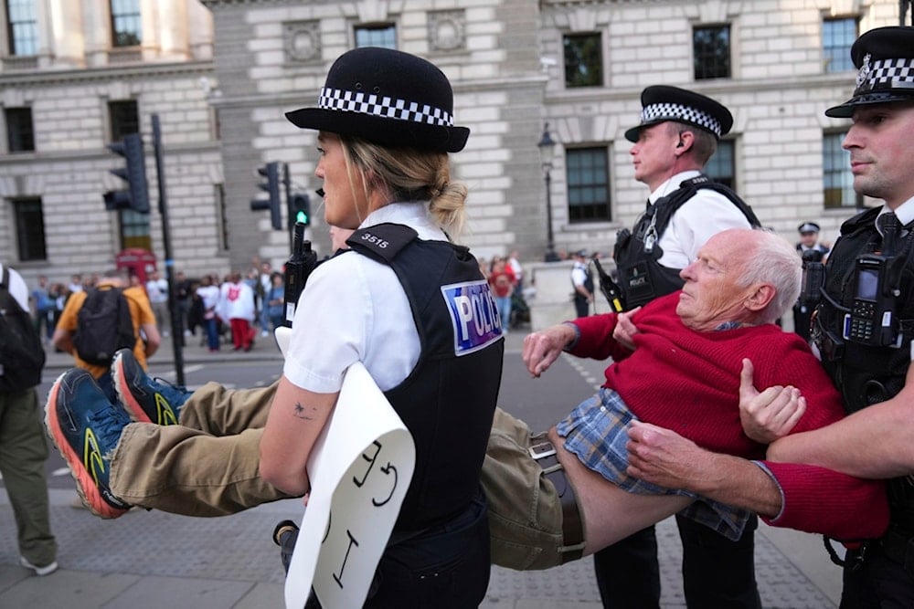 Police officers carry a protester during a protest to support Palestine Action in London, Saturday, Sept. 6, 2025.(AP Photo/Joanna Chan)