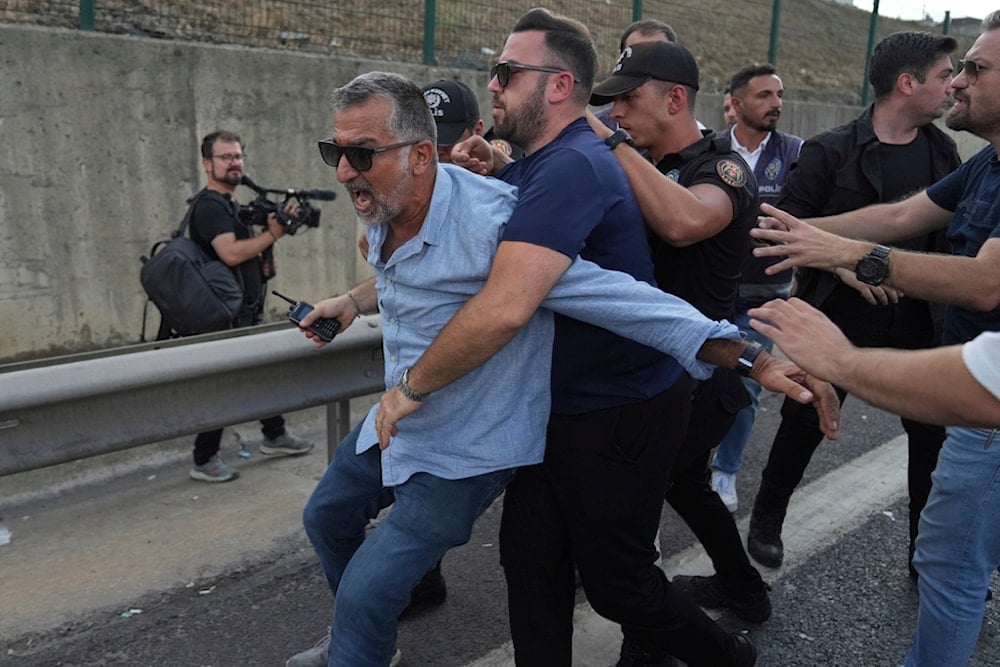A supporter of Turkey's main opposition Republican People's Party (CHP) scuffles with police officers outside the party's headquarters in Istanbul, Turkey, Monday, September 8, 2025 (AP)