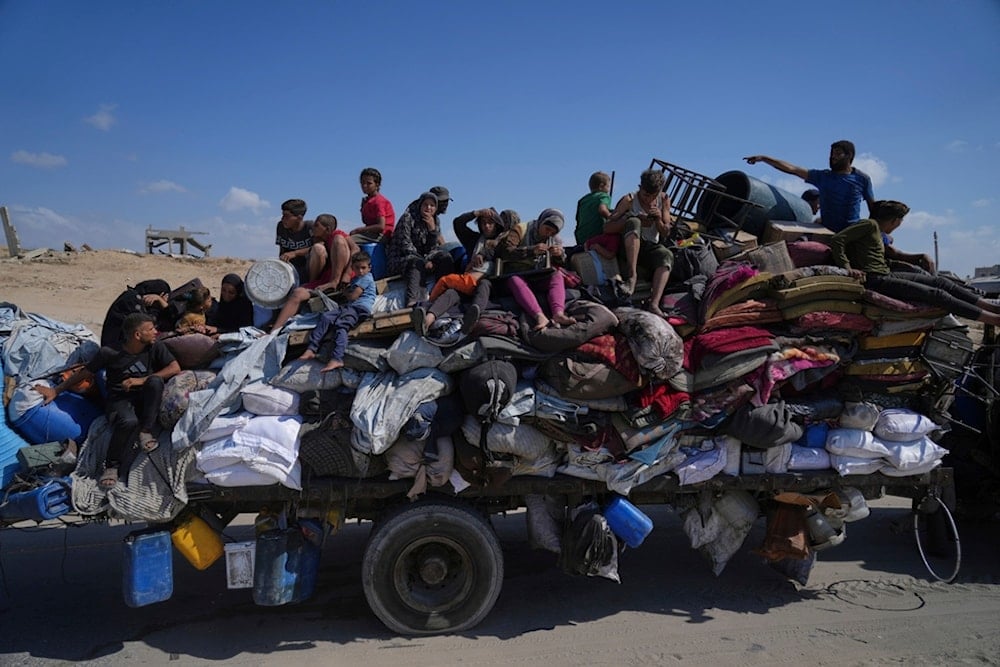 Displaced Palestinians fleeing northern Gaza carry their belongings along the coastal road toward southern Gaza, Tuesday, September 9 (AP)