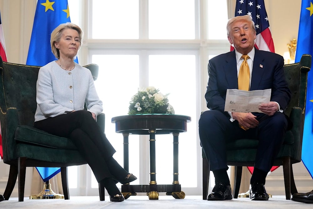 President Donald Trump reads from a paper and European Commission President Ursula von der Leyen listens after reaching a trade deal between the US and the EU, July 27, 2025 (AP)